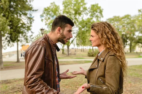 Парень эмоционально разговаривает с девушкой в парке