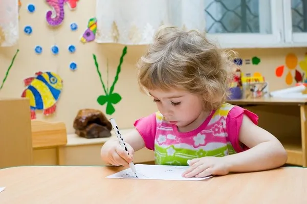 Девочка рисует в детском саду